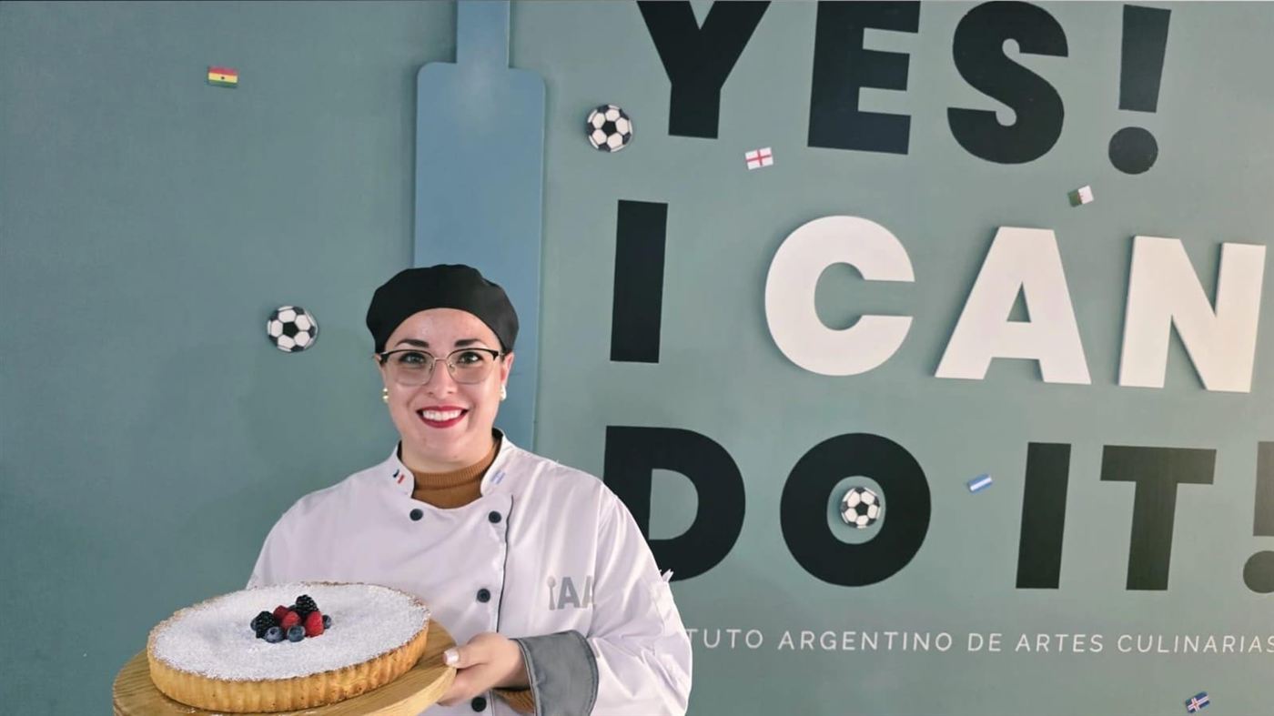 Bárbara, fundadora de Apapacho, sonriendo con una tarta de frutos rojos en el Instituto Argentino de Artes Culinarias