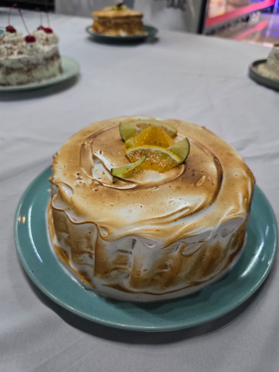 Pastel cubierto de merengue flameado con cítricos